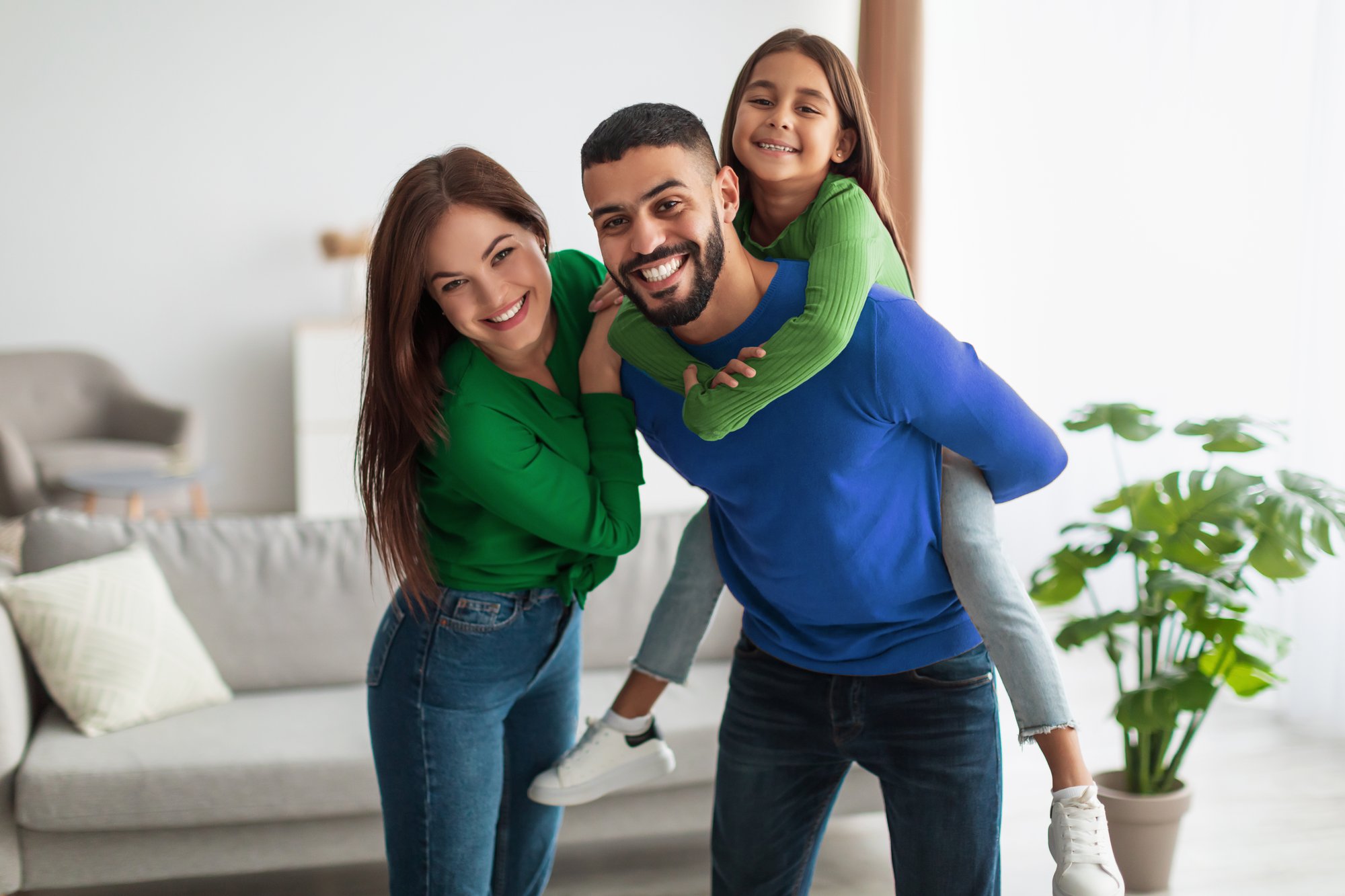 spending-time-with-family-is-fun-portrait-excited-middle-eastern-man-woman-girl-laughing-posing-home-living-room-cheerful-father